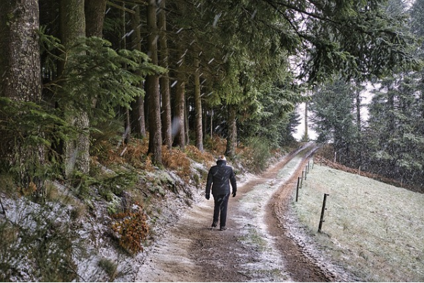 A man on a frosty trail hiking in winter