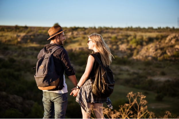 a man and woman hold hands on a hiking trail in texas