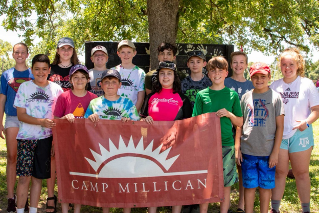 camp millican campers pose around a camp millican sign